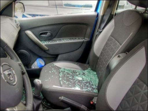 Shattered glass on the front seats of a car, indicating possible break-in or vandalism.